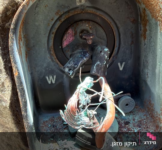 חוטים חשמליים שרופים בתוך מתקן מתכת חלוד